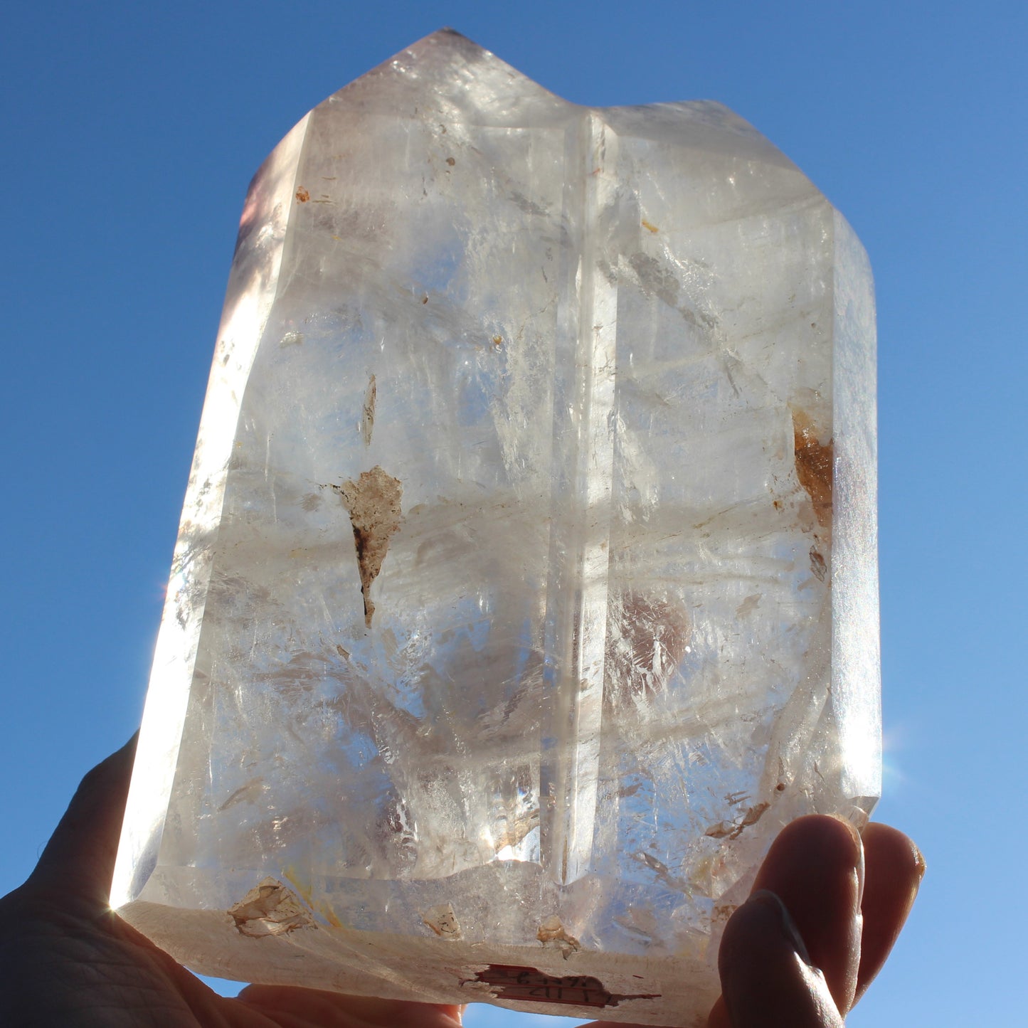 Clear Quartz double-pillar obelisk 1655g in sunshine, held in hand