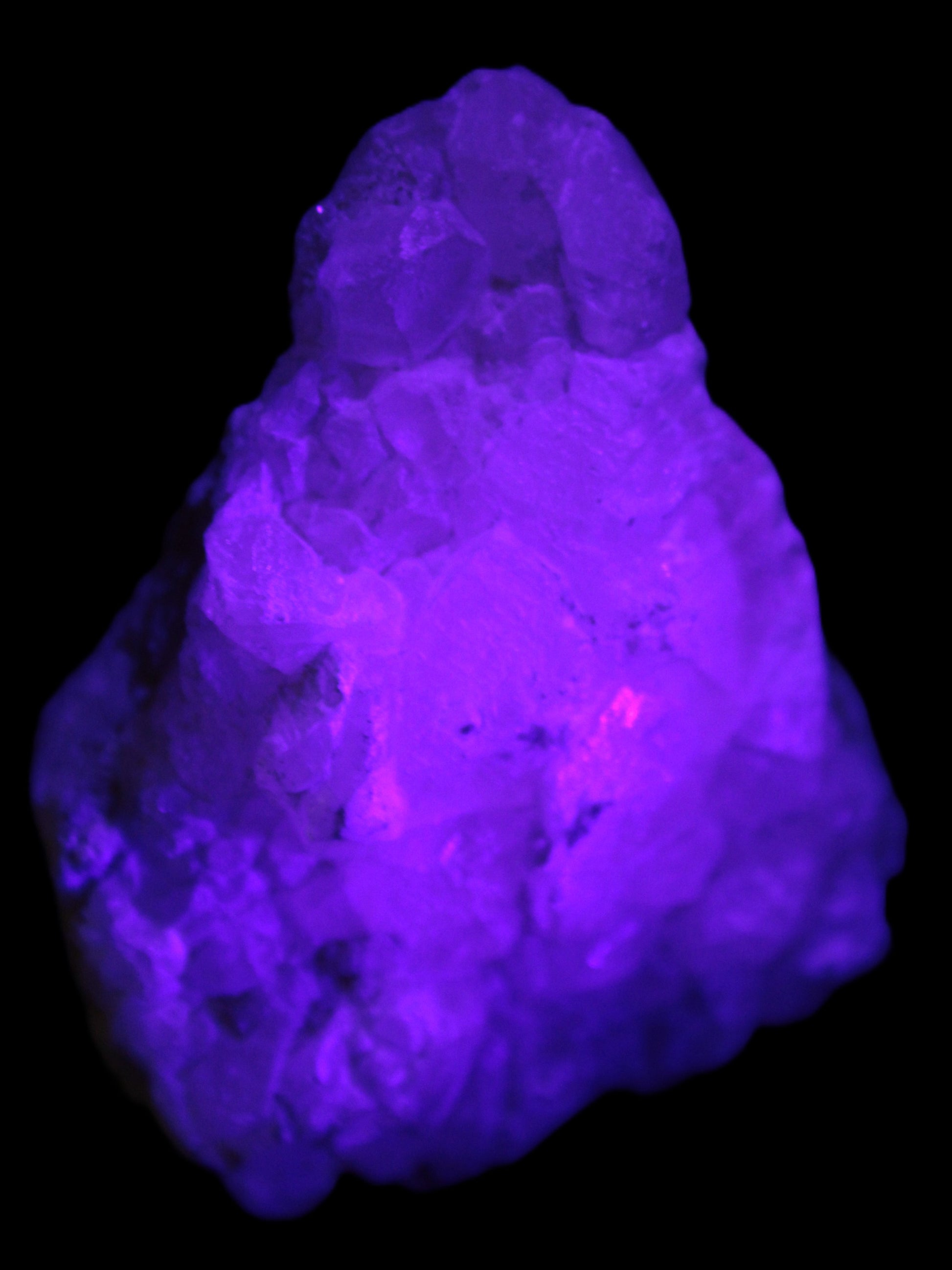 Calcite UV-reactive crystal cluster 130g in UV light 395nm