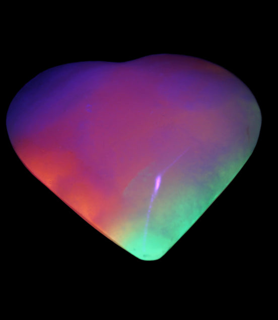 Calcite dyed and UV reactive hand-carved heart 89g in UV light - Rocks and Things Store