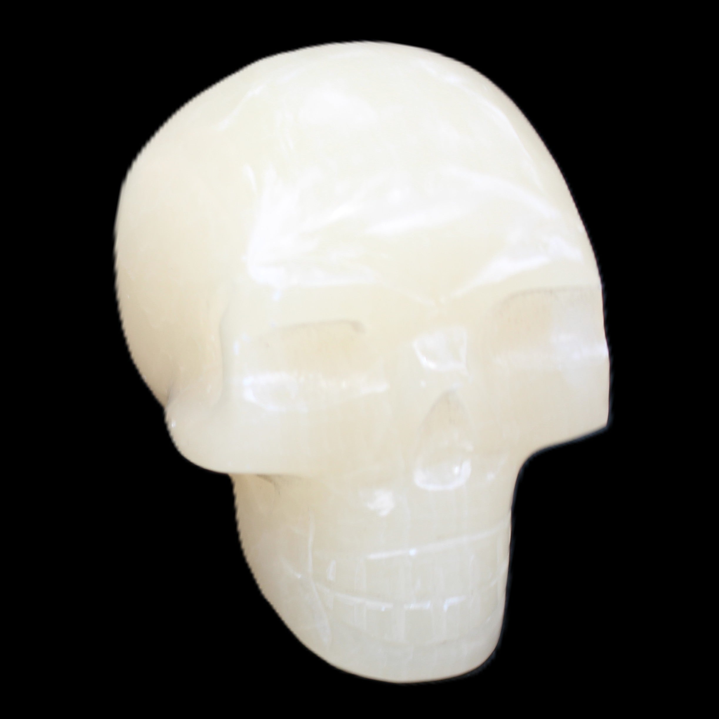 Honey Calcite skull hand-carved 58*48*40mm 175g in sunlight - Rocks and Things Store