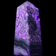 Chocolate Calcite obelisk with caves 95*40mm 217g in UV light - Rocks and Things Store