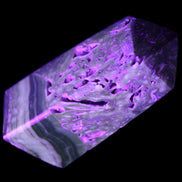 Chocolate Calcite obelisk with caves 95*40mm 217g in UV light - Rocks and Things Store