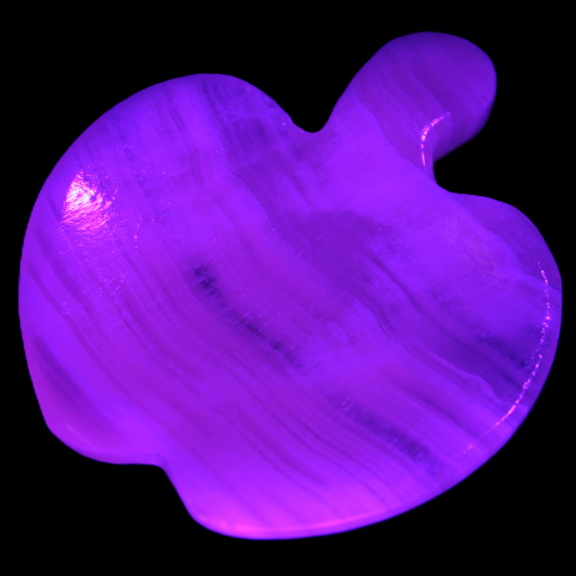 Mangano Calcite hand-carved apple 50-59g in UV light - Rocks and Things Store