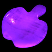 Mangano Calcite hand-carved apple 50-59g in UV light - Rocks and Things Store