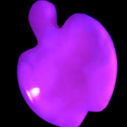 Mangano Calcite hand-carved apple 50-59g in UV light - Rocks and Things Store