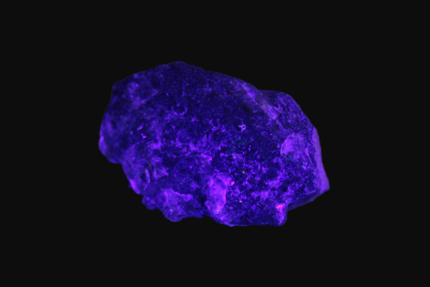 Clear Fluorite with UV reactive mica matrix in UV light