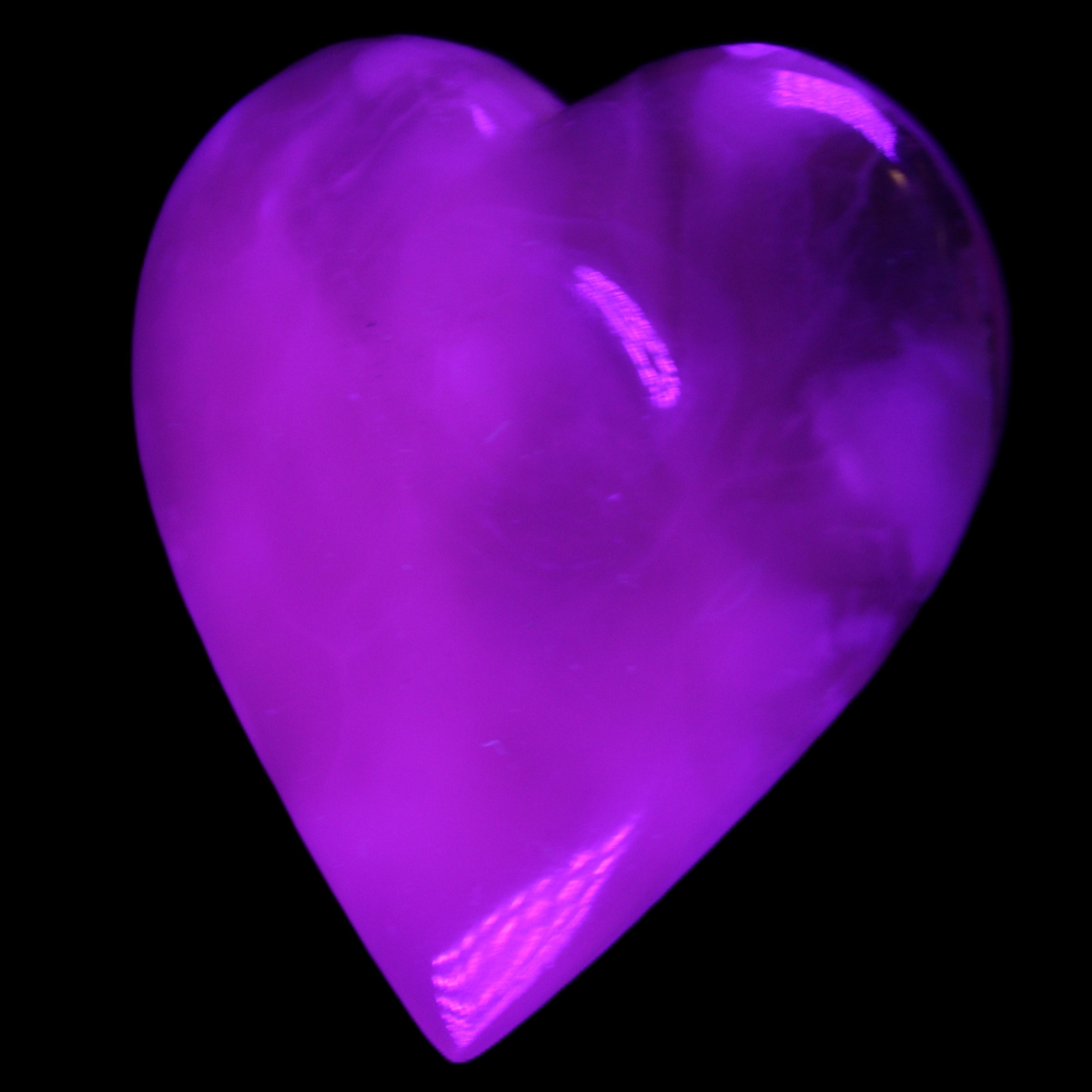 Mangano Calcite hand-carved heart 73*78*20mm 160g in UV light - Rocks and Things Store