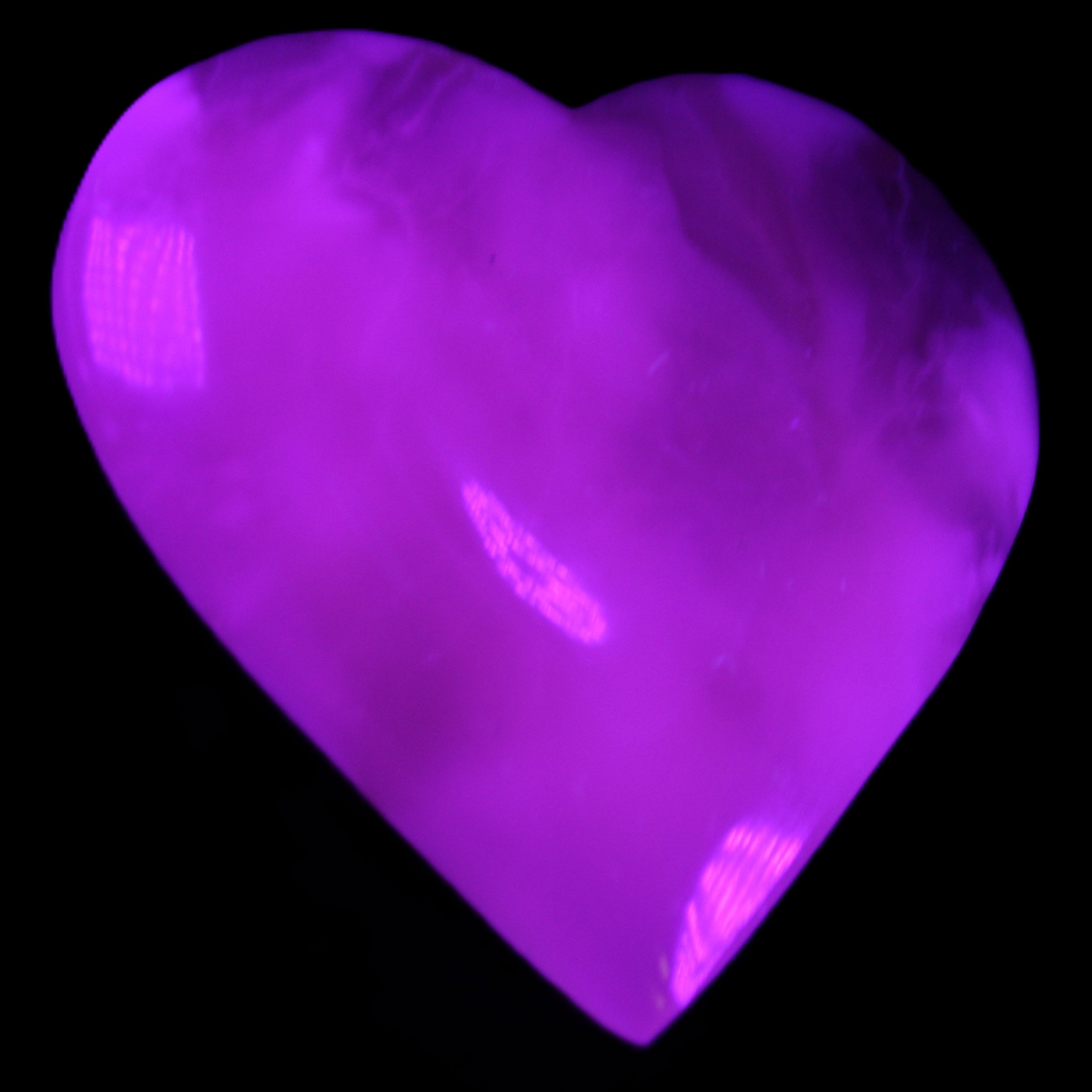 Mangano Calcite hand-carved heart 73*78*20mm 160g in UV light - Rocks and Things Store