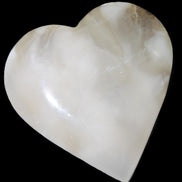 Mangano Calcite hand-carved heart 73*78*20mm 160g in sunlight - Rocks and Things Store