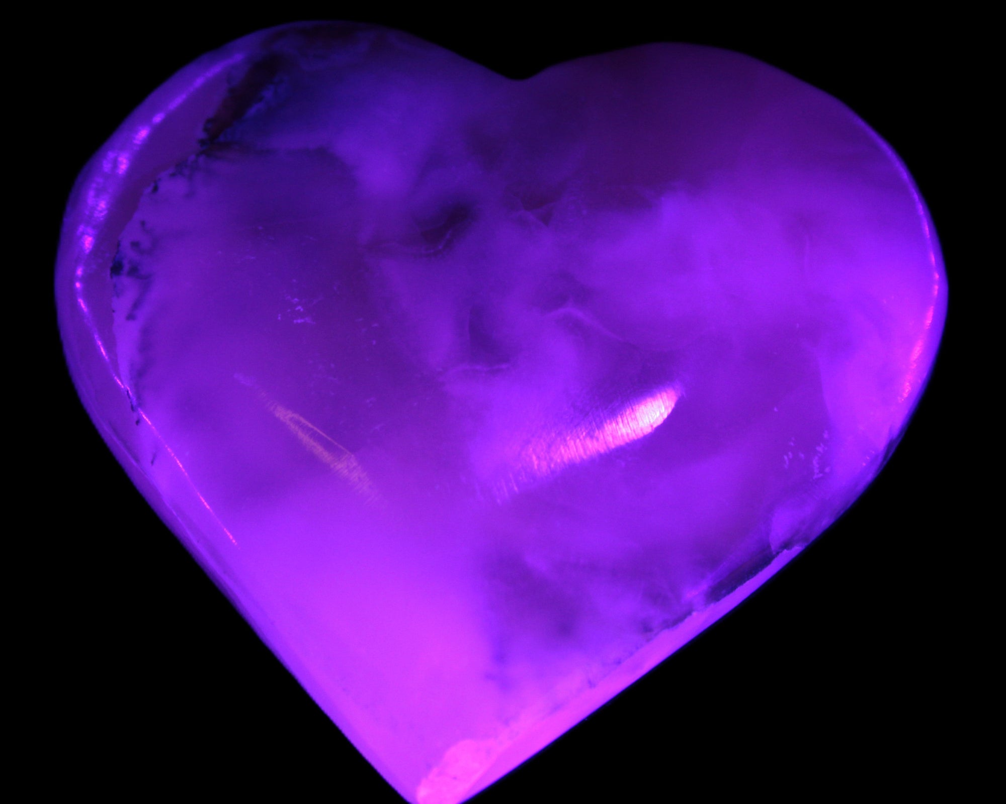 Mangano Calcite hand-carved heart 67mm  120/125g  in UV light - Rocks and Things Store