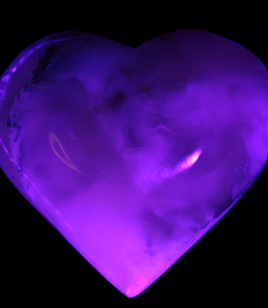Mangano Calcite hand-carved heart 67mm  120/125g  in UV light - Rocks and Things Store