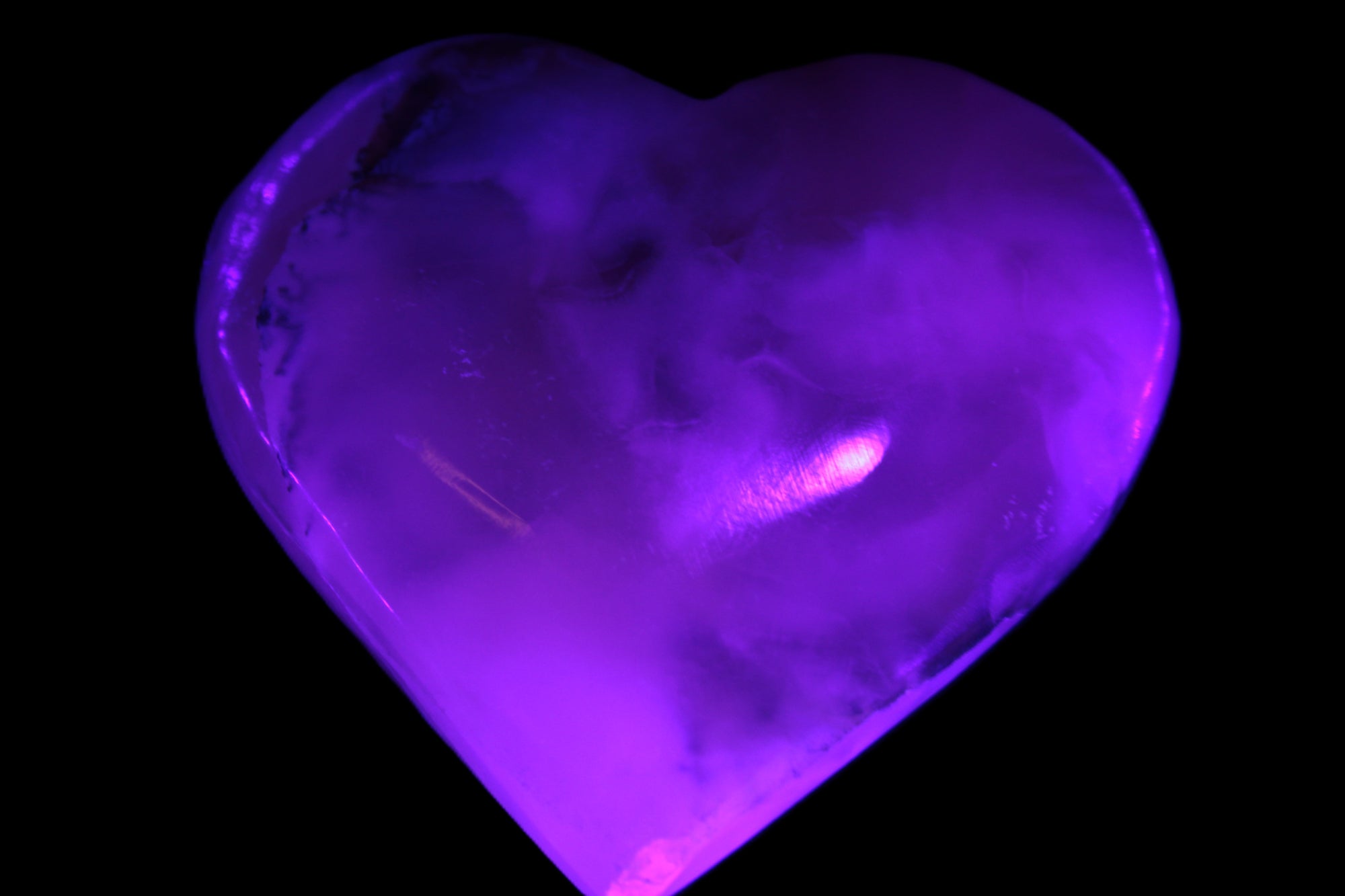 Mangano Calcite hand-carved heart 67mm  120/125g  in UV light - Rocks and Things Store