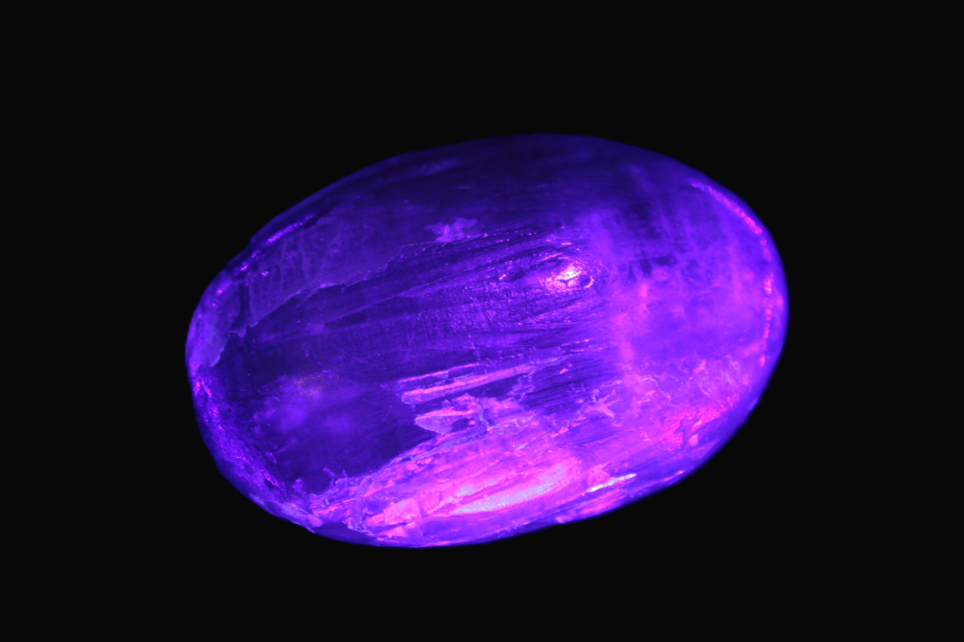 Pink Sorbet Calcite palm stone in UV light