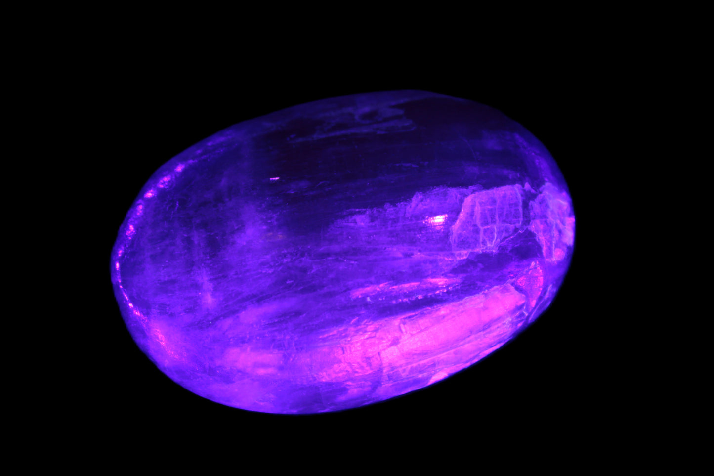 Pink Sorbet Calcite palm stone in UV light