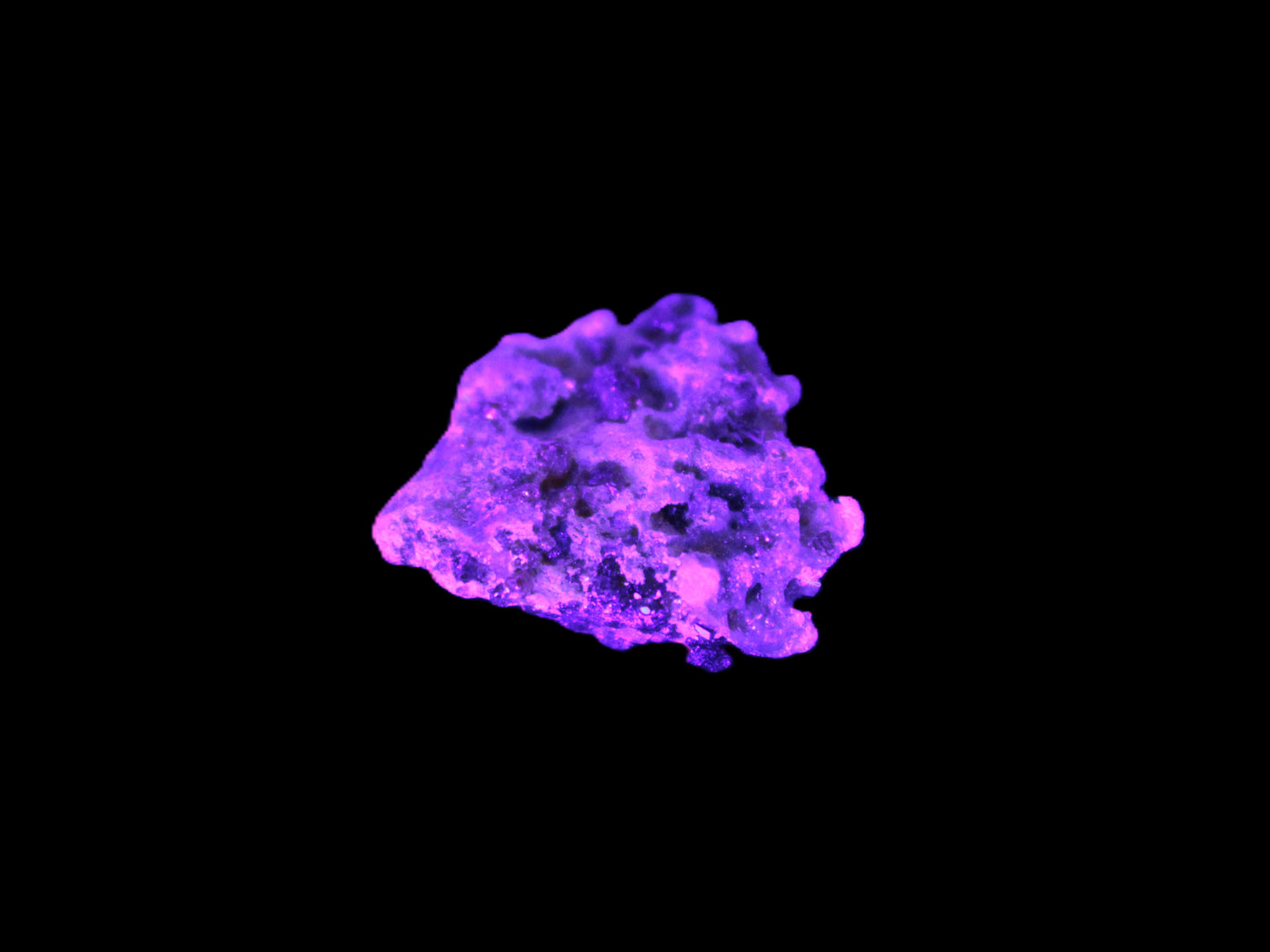 Tiny Spessartine Garnet cluster in UV light