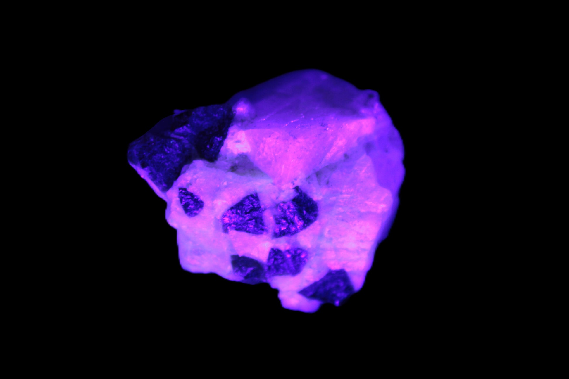 Black Elbaite cluster in matrix in UV light