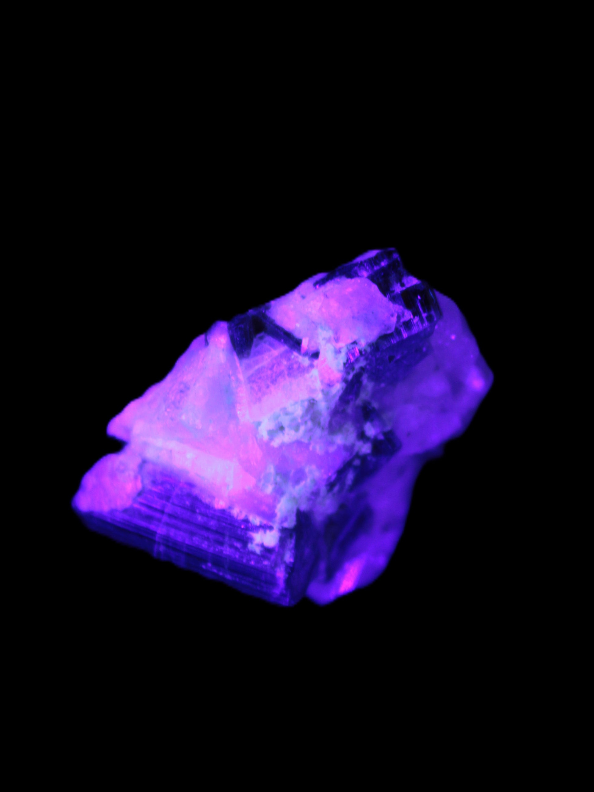 Black Elbaite cluster in matrix in UV light