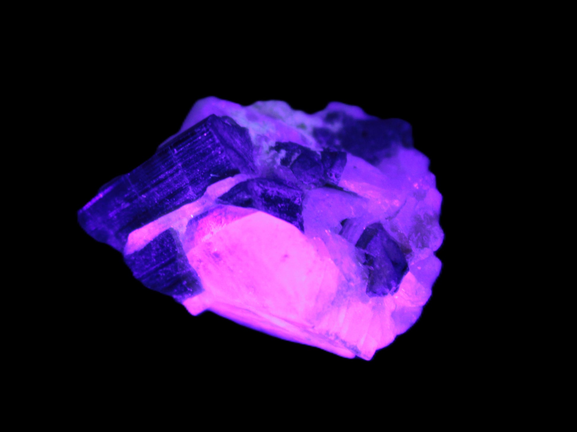 Black Elbaite cluster in matrix in UV light