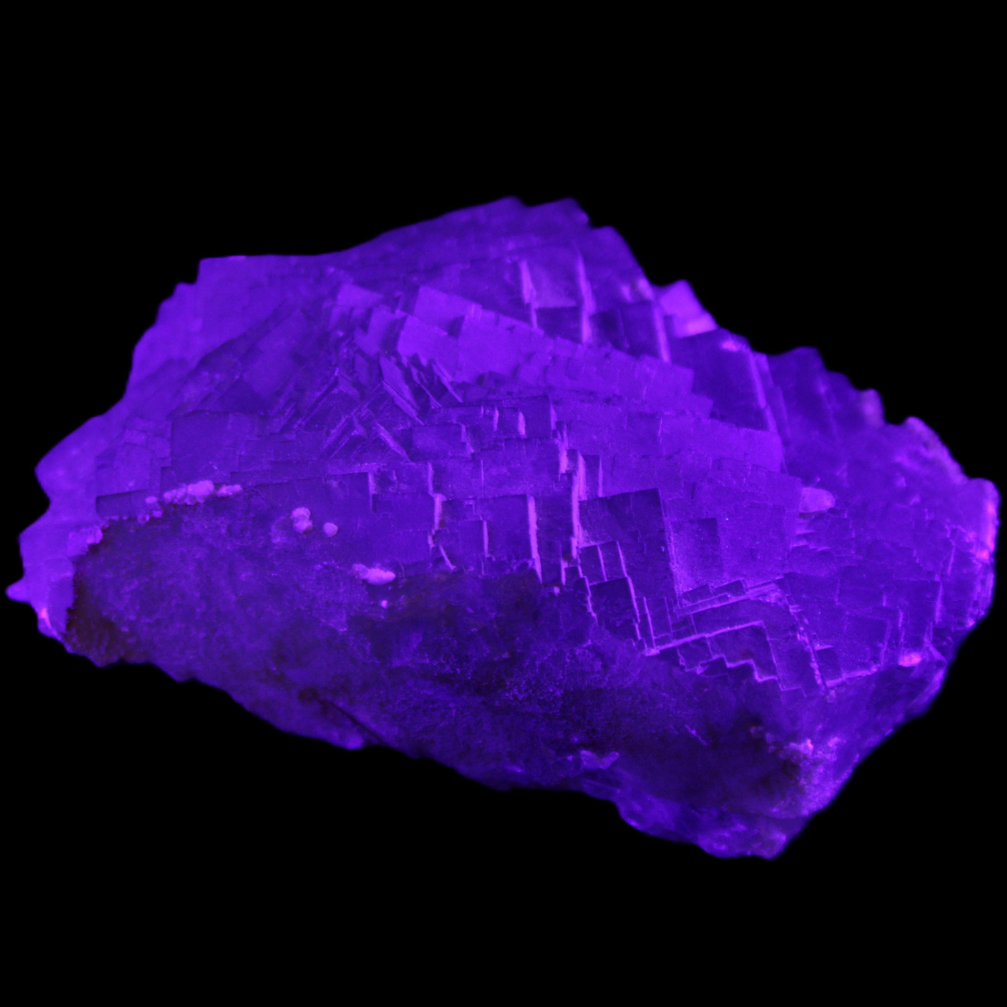 Clear Fluorite cubic stepped cluster 104*72*50mm 660g in UV light - Rocks and Things Store