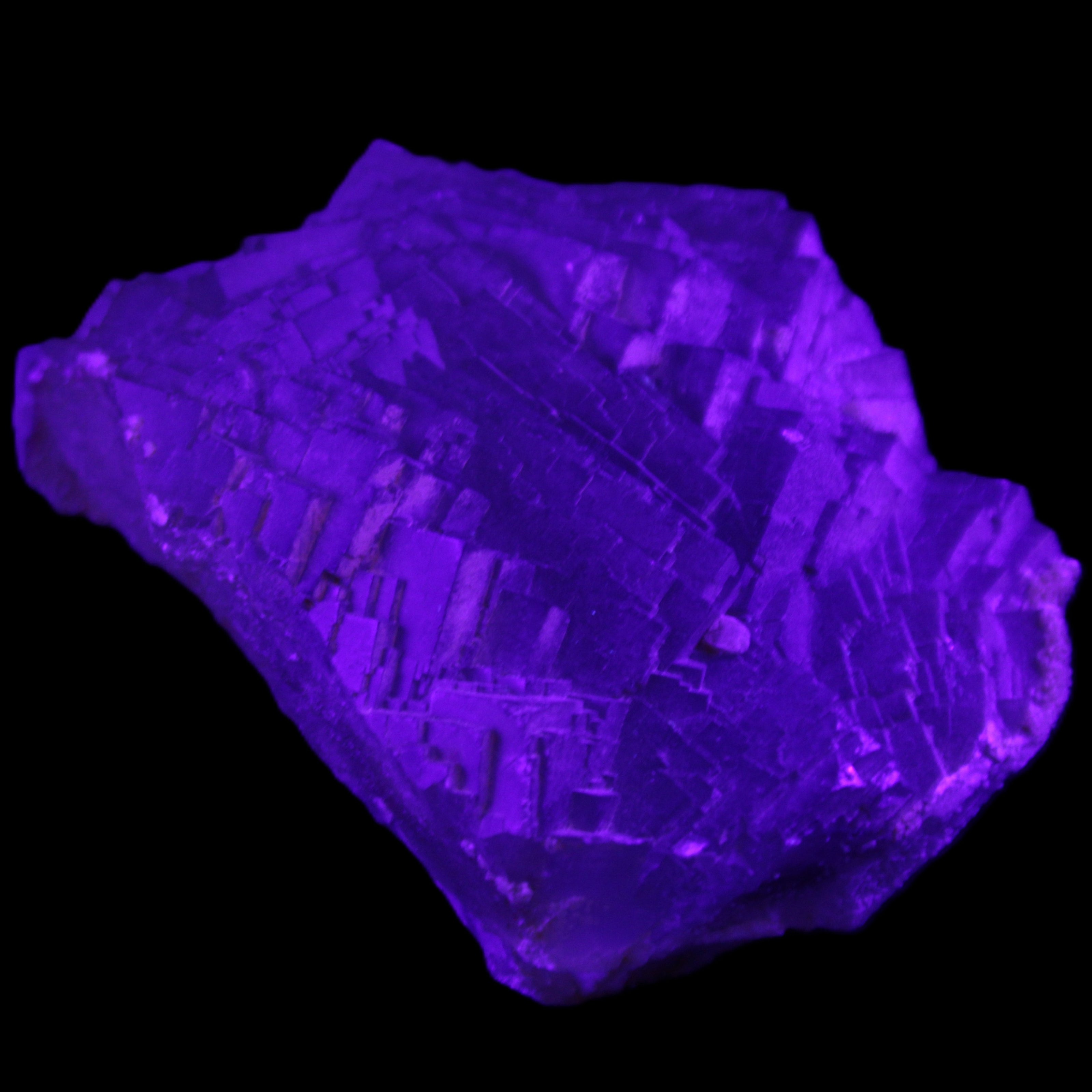 Clear Fluorite cubic stepped cluster 104*72*50mm 660g in UV light - Rocks and Things Store