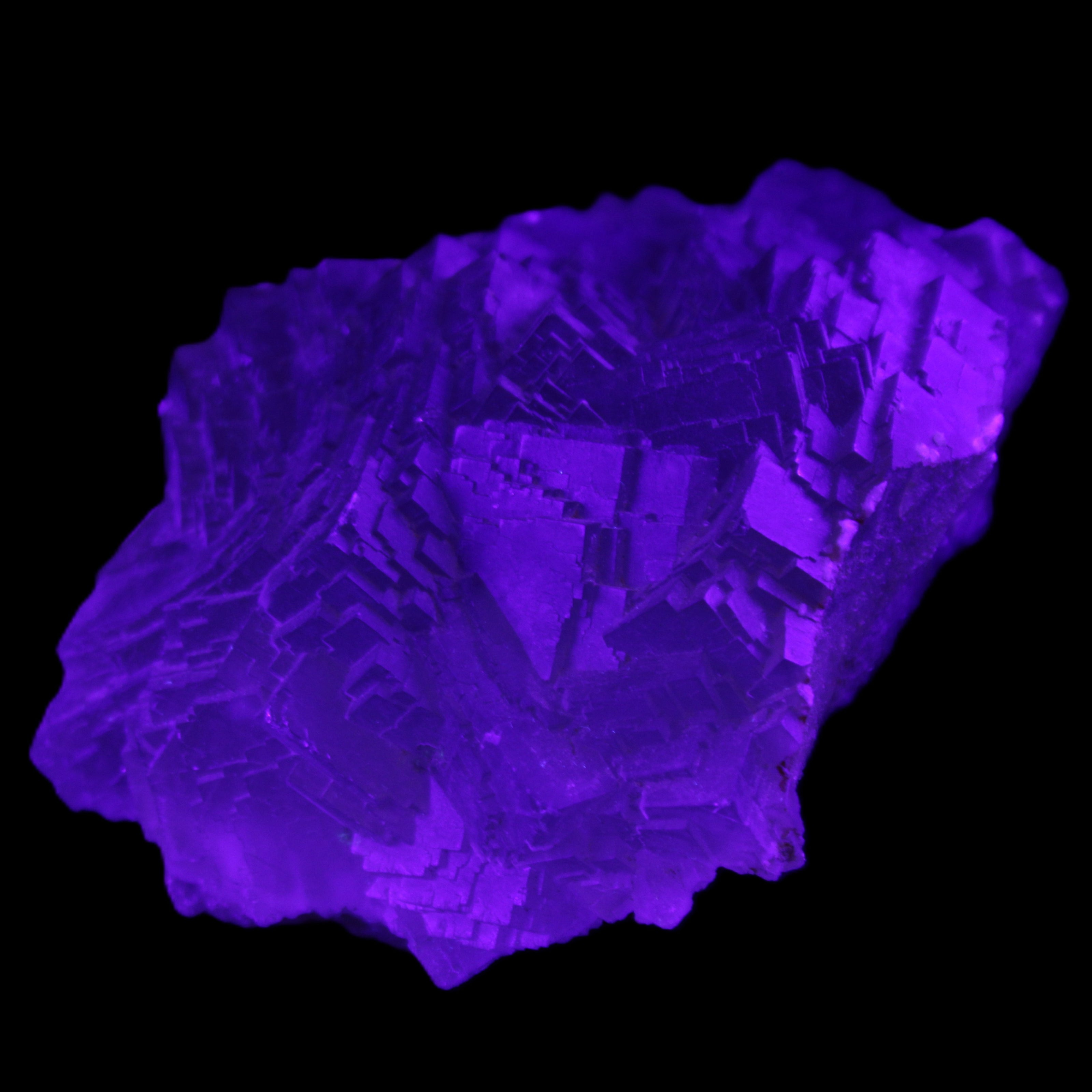 Clear Fluorite cubic stepped cluster 104*72*50mm 660g in UV light - Rocks and Things Store
